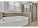 Bathroom featuring a white soaking tub with a tile surround, and glass enclosed shower at 3320 Pleasant Springs Dr, Cumming, GA 30028