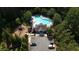 Aerial view of the community pool and clubhouse, surrounded by lush greenery and parking at 3320 Pleasant Springs Dr, Cumming, GA 30028
