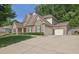 Spacious home featuring a three-car garage and a wide driveway with lush green lawn at 3320 Pleasant Springs Dr, Cumming, GA 30028
