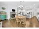 Open kitchen and dining area with white cabinets, stainless steel appliances, island seating, and cozy fireplace at 3320 Pleasant Springs Dr, Cumming, GA 30028