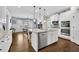 Open kitchen with granite counters, stainless appliances, and an island with bar seating flows into a cozy dining area at 3320 Pleasant Springs Dr, Cumming, GA 30028