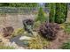 Beautifully landscaped backyard with brick retaining wall, trees and shrubbery at 3320 Pleasant Springs Dr, Cumming, GA 30028