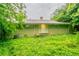 View of the backyard featuring a brick home exterior surrounded by mature trees and lush ground cover at 3409 Hyland Dr, Decatur, GA 30032