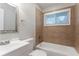 Bathroom featuring a tub with tile surround, a mirror, and a sink at 3409 Hyland Dr, Decatur, GA 30032