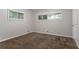A modest bedroom featuring neutral walls, carpeted flooring, and bright natural light from two windows at 3409 Hyland Dr, Decatur, GA 30032