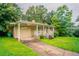 Quaint home with attached carport and cozy front porch, set on a lush green lawn at 3409 Hyland Dr, Decatur, GA 30032