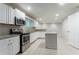 Well-lit kitchen with stainless steel appliances, an island, granite countertops and white cabinets at 3409 Hyland Dr, Decatur, GA 30032
