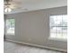 Neutral bedroom features two windows for natural light and neutral walls at 4735 Widgeon Way, Cumming, GA 30028