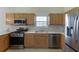 Kitchen with stainless steel appliances, a microwave, and oak cabinets at 4735 Widgeon Way, Cumming, GA 30028
