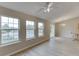 Bright living room featuring hardwood floors, three windows, a ceiling fan and sliding glass doors at 4735 Widgeon Way, Cumming, GA 30028
