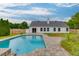 Backyard view of a refreshing inground pool with brick paver patio, surrounded by a well-maintained lawn and privacy fence at 4735 Widgeon Way, Cumming, GA 30028