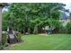 Large backyard featuring a wooden deck with a grill, a playset, and a hammock at 1952 Sugarstone Dr, Lawrenceville, GA 30043