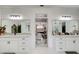 Bathroom featuring double vanities, large mirrors, and an open view to the bedroom at 1952 Sugarstone Dr, Lawrenceville, GA 30043