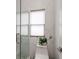 Modern bathroom with marble tile, glass shower door, and a window for natural light at 1952 Sugarstone Dr, Lawrenceville, GA 30043
