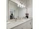 Bathroom featuring double sinks, white cabinets, quartz countertop, and modern lighting at 1952 Sugarstone Dr, Lawrenceville, GA 30043