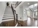 Bright foyer with dark wood floors, staircase with black iron railing, and view into adjacent rooms at 1952 Sugarstone Dr, Lawrenceville, GA 30043