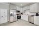 Well-lit kitchen with stainless steel appliances, white cabinets, and light ceramic tile flooring at 1952 Sugarstone Dr, Lawrenceville, GA 30043