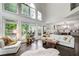Open-concept living area with large windows and a view into the modern kitchen at 1952 Sugarstone Dr, Lawrenceville, GA 30043