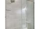 Modern shower with gray tiling, glass door, and recessed lighting at 1952 Sugarstone Dr, Lawrenceville, GA 30043
