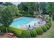 Community swimming pool with blue umbrellas surrounded by manicured landscaping at 1952 Sugarstone Dr, Lawrenceville, GA 30043