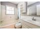 This bathroom features a bathtub, window, toilet, vanity, mirror, and overhead shelving at , Forest Park, GA 30297