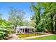 Backyard pool surrounded by lush greenery, patio, and fence in need of maintenance at , Forest Park, GA 30297