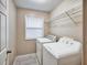 Well-lit laundry room with side-by-side washer and dryer and storage shelf at 1625 Orlando Sw St, Atlanta, GA 30311