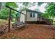 View of the home's backyard with a wooden swing and stairs leading up to the house at 407 Doris Dr, Woodstock, GA 30188