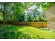 Fenced-in backyard with a lush lawn, trees, and space for gardening or outdoor activities at 407 Doris Dr, Woodstock, GA 30188