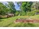 Expansive backyard featuring a garden bed, lush green lawn, and surrounding mature trees at 407 Doris Dr, Woodstock, GA 30188