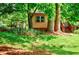 A backyard featuring a quaint shed nestled among mature trees, offering a peaceful and private outdoor space at 407 Doris Dr, Woodstock, GA 30188