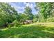 Lush backyard offering ample space, mature trees, a storage shed, and a garden plot at 407 Doris Dr, Woodstock, GA 30188