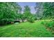 Spacious backyard with lush greenery, storage shed, and potential for gardening or recreation at 407 Doris Dr, Woodstock, GA 30188