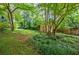 Secluded backyard featuring lush landscaping, mature trees, and a convenient storage shed at 407 Doris Dr, Woodstock, GA 30188