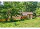 Backyard view showcases a cozy porch, mature trees, green grass, and a tranquil outdoor space at 407 Doris Dr, Woodstock, GA 30188
