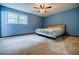 Spacious carpeted bedroom with ceiling fan and good natural light from the window at 407 Doris Dr, Woodstock, GA 30188