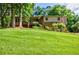 Charming two-story home with a well-maintained lawn and mature trees, showcasing its inviting and picturesque setting at 407 Doris Dr, Woodstock, GA 30188
