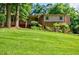 Charming two-story home featuring a well-manicured lawn and mature trees, creating a serene and inviting atmosphere at 407 Doris Dr, Woodstock, GA 30188