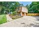 Exterior view of home, featuring a driveway leading to a two-car garage and manicured landscaping at 407 Doris Dr, Woodstock, GA 30188