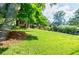 Lush front yard with mature trees shading a charming home, offering a peaceful and inviting outdoor space at 407 Doris Dr, Woodstock, GA 30188