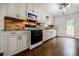 Modern kitchen with a brick backsplash, farmhouse sink, and stainless steel appliances at 407 Doris Dr, Woodstock, GA 30188