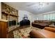 Cozy living room with a striking stone fireplace, comfortable seating, and a ceiling fan for year-round comfort at 407 Doris Dr, Woodstock, GA 30188