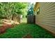 Side yard with fresh green ground cover, a wooden fence and an iron gate at 407 Doris Dr, Woodstock, GA 30188