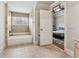 Bright bathroom with a tub, window, and tile surround with a view into the bedroom at 3410 Enclave Mill Ct, Dacula, GA 30019