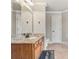 Bright bathroom with granite countertop, wood cabinets, and large mirror with decorative lighting at 3410 Enclave Mill Ct, Dacula, GA 30019