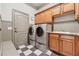 Laundry room with washer, dryer, cabinets, sink, beadboard paneling, and checkered tile floors at 3410 Enclave Mill Ct, Dacula, GA 30019