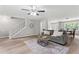 Open-concept living room featuring wood floors, a ceiling fan, and access to dining room at 103 Seabolt Dr, Locust Grove, GA 30248