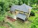 Aerial view of backyard, covered porch, outdoor seating, and lush landscaping at 135 Crimson Rdg, Tyrone, GA 30290