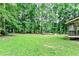 Large backyard with green lawn and a playset, partially surrounded by lush green trees at 135 Crimson Rdg, Tyrone, GA 30290
