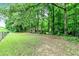 Large backyard space surrounded by lush green trees and a fence at 135 Crimson Rdg, Tyrone, GA 30290